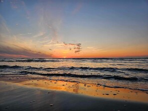 A beach with waves and a sunset. - 6 Person Holiday Home in Bindslev (Bindslev)
