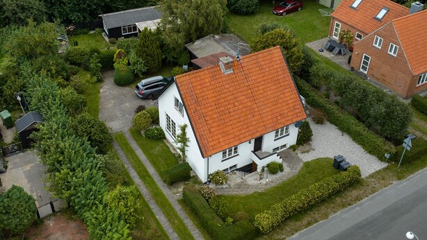 A residential area with a house featuring a red-tiled roof, a driveway, and a well-maintained lawn. - 6 Person Holiday Home in Bindslev (Bindslev)