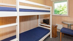 A bunk bed room with wooden walls, a window with a view of greenery, and a small table with a bench. - 6 Person Holiday Home in Logstor (Logstor)