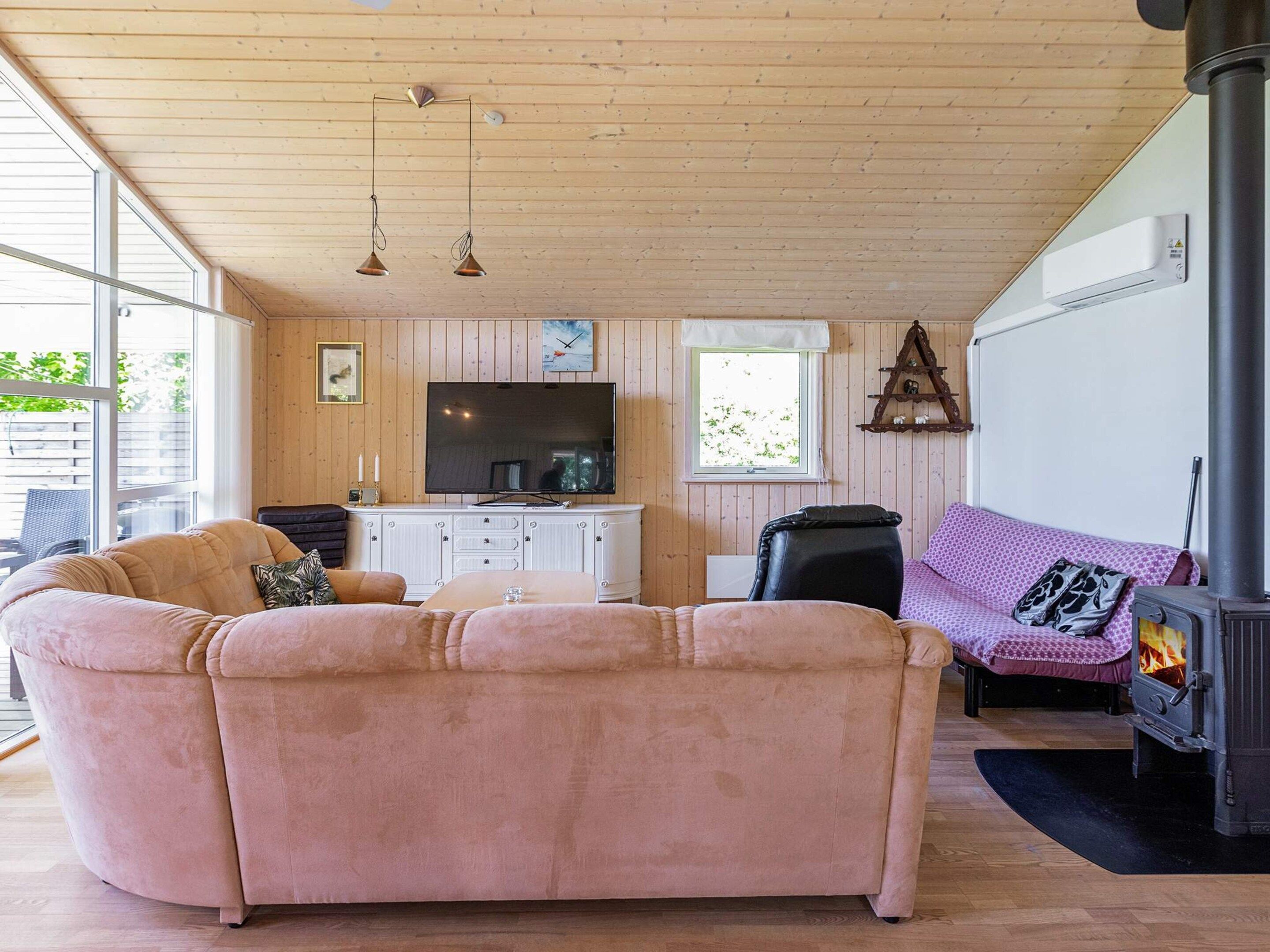A cozy living room with a sofa, a television, and a fireplace.
