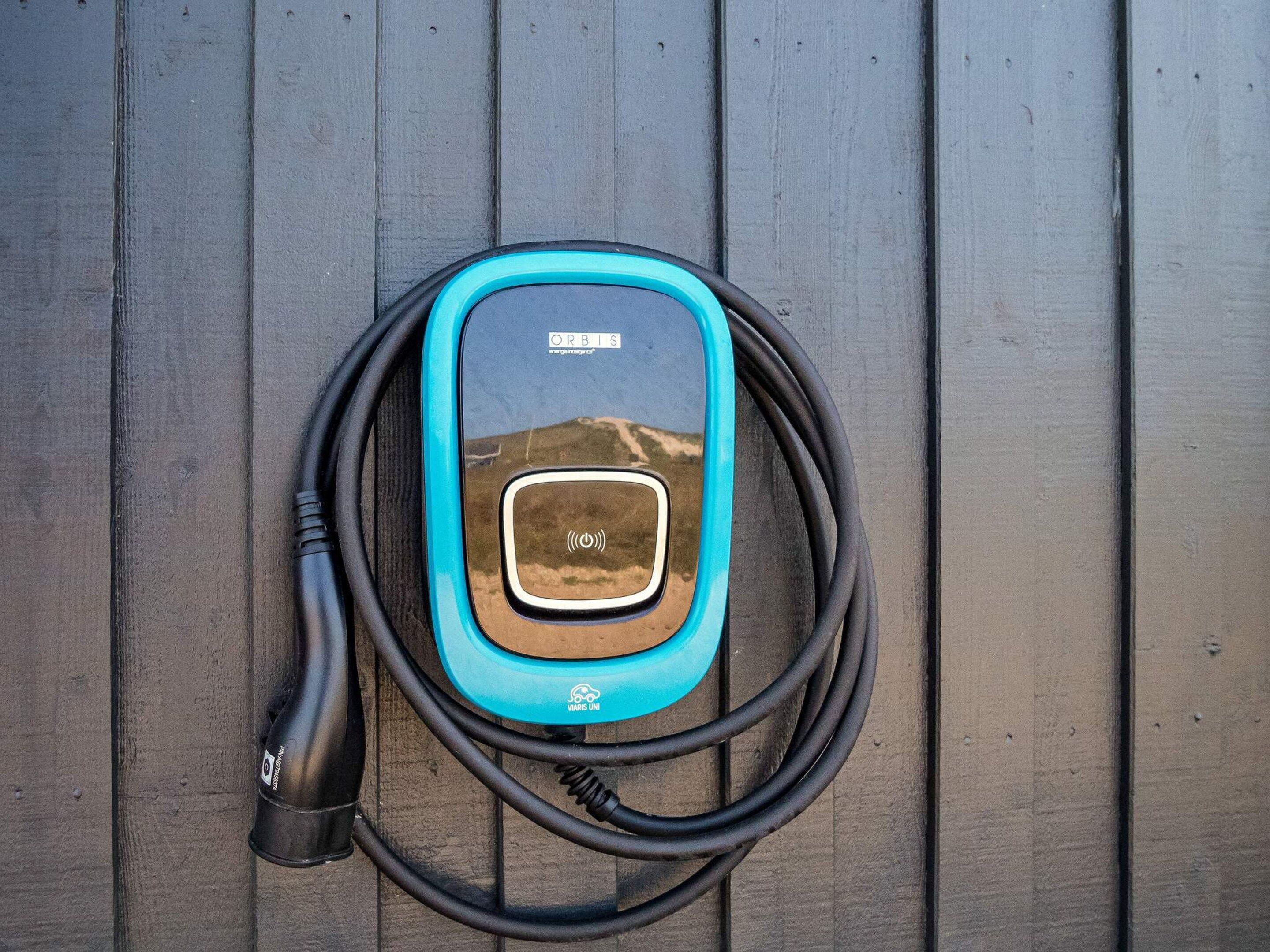 An electric vehicle charging station with a cable connected to a car charger.