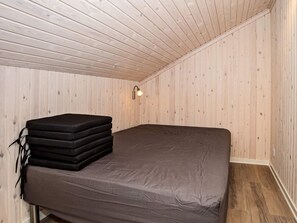 A small, single-bed room with wooden walls and a sloped ceiling. - 8 Person Holiday Home in Harboore (Harboore)