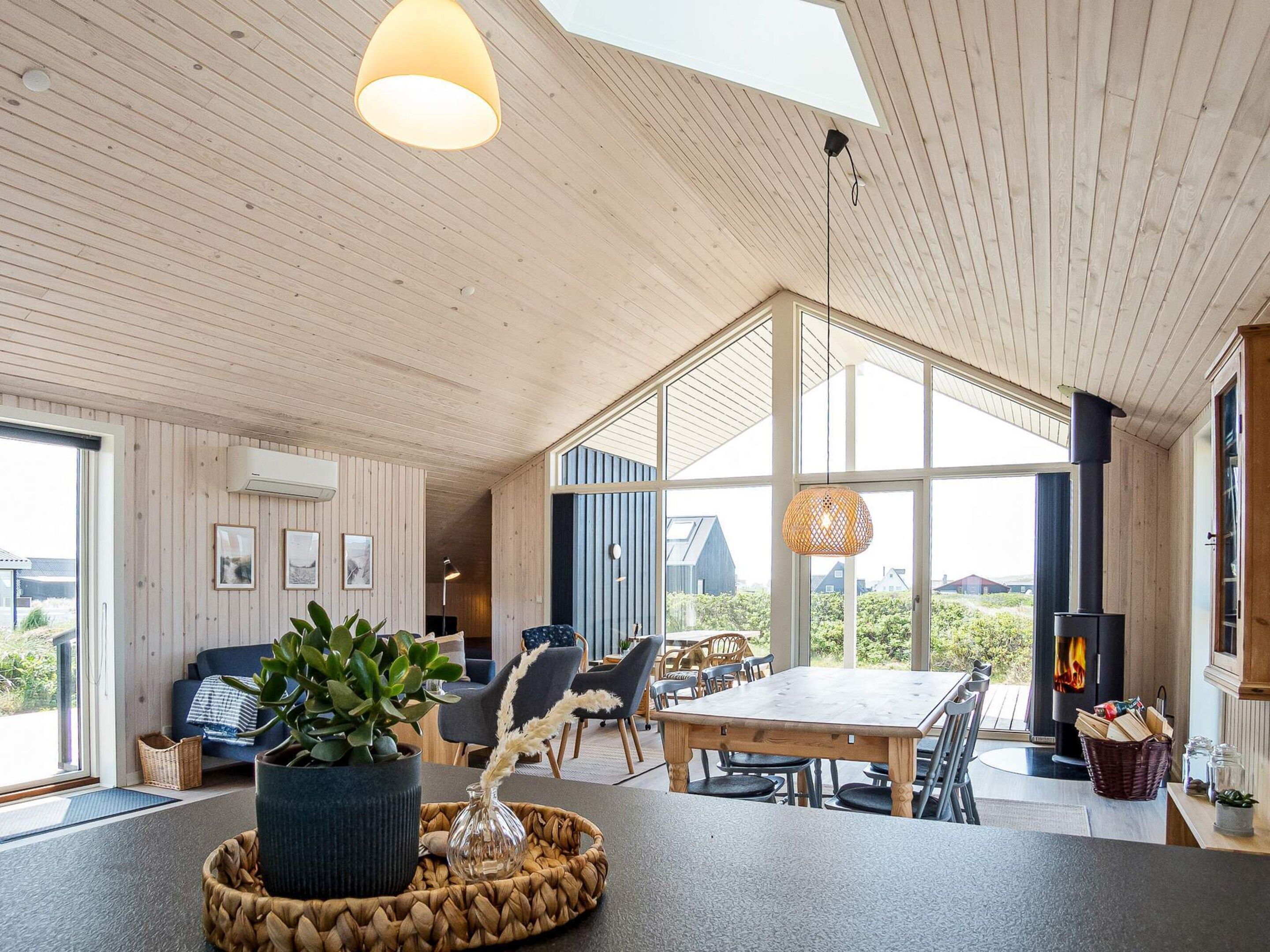 A spacious living area with a large wooden table, comfortable seating, and a fireplace.