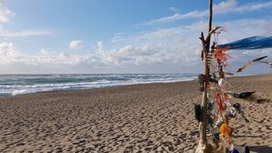 A beach with a sculpture made of various objects and debris. - 8 Person Holiday Home in Harboore (Harboore)