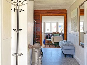A hallway with a coat rack, a radiator, and a bench. There is a window with a view of the outside. - 4 Star Holiday Home in Mariestad (Mariestad)