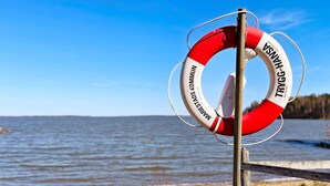 Une bouée de sauvetage fixée à un poteau, au bord de l’eau.