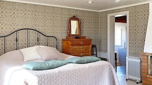 A bedroom with a bed, dresser, mirror, and radiator. - 4 Star Holiday Home in Mariestad (Mariestad)