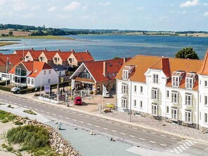 A coastal town with traditional buildings, a road, and a body of water. - 4 Person Holiday Home in Hejls (Hejls)