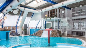 An indoor swimming pool with a slide, a staircase, and lounge chairs. - 4 Person Holiday Home in Hejls (Hejls)