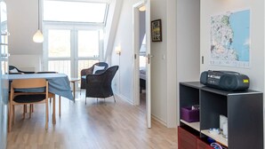 A modern interior with a dining area, a seating area with a view, and a map on the wall. - 4 Person Holiday Home in Hejls (Hejls)