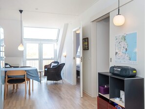A modern interior with a dining area, a seating area with a view, and a map on the wall. - 4 Person Holiday Home in Hejls (Hejls)