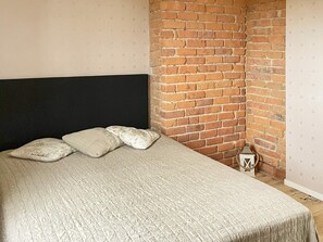 A bed with a black headboard, a beige bedspread, and three pillows. - 4 Star Holiday Home in Vastra Amtervik (Vastra Amtervik)