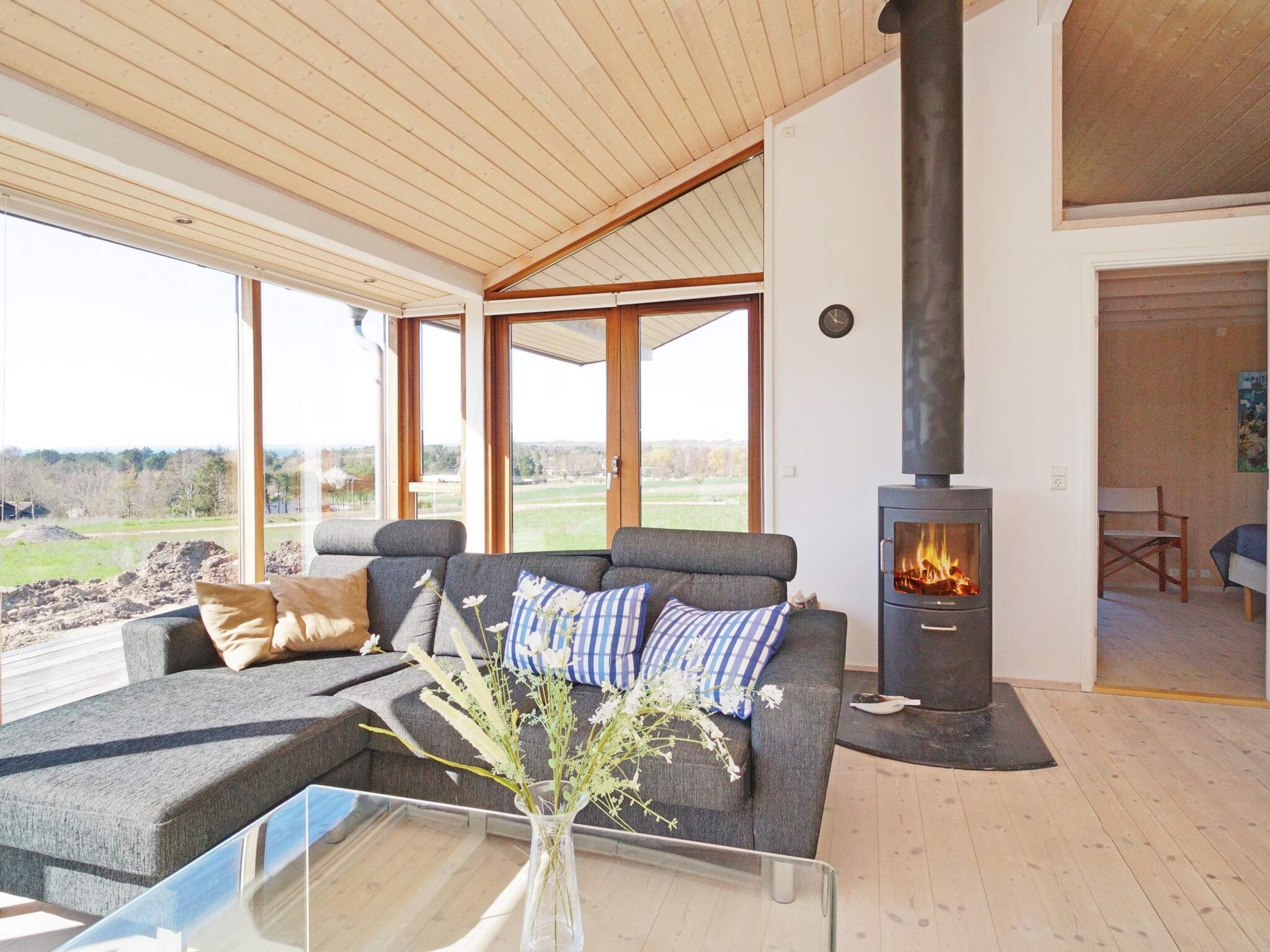A modern living room with a sofa, a glass coffee table, and a fireplace.