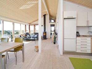 Una cucina moderna con mobili bianchi, piano cottura integrato e zona pranzo con tavolo e sedie.