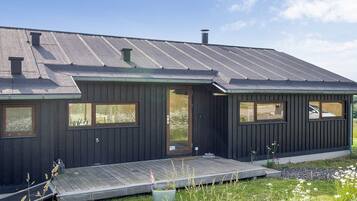 A modern house with a dark exterior, a sloped roof, and a front porch.