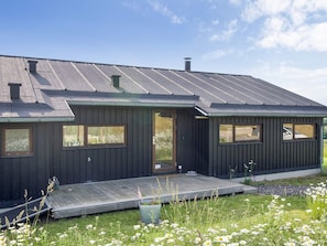 A modern house with a dark exterior, a sloped roof, and a front porch. - 8 Person Holiday Home in Store Fuglede (Store Fuglede)