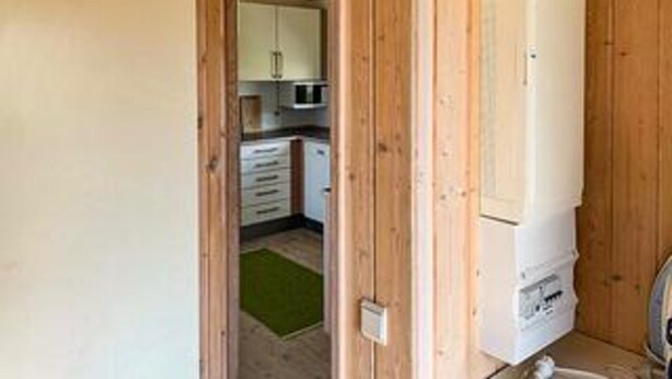 Une cuisine avec des meubles de rangement en bois, un four à micro-ondes et un réfrigérateur.