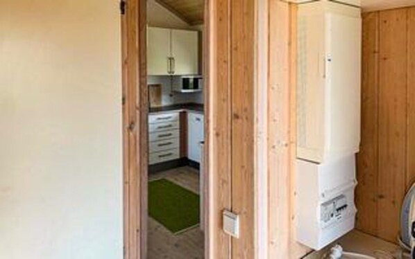 A kitchen with wooden cabinets, a microwave, and a refrigerator.