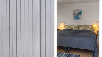 A bedroom with a bed, a wall-mounted painting, and a bedside lamp.