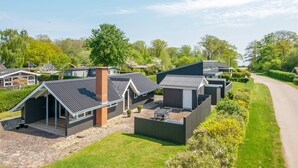 Una zona residenziale con case moderne, un vialetto asfaltato e un prato curato.