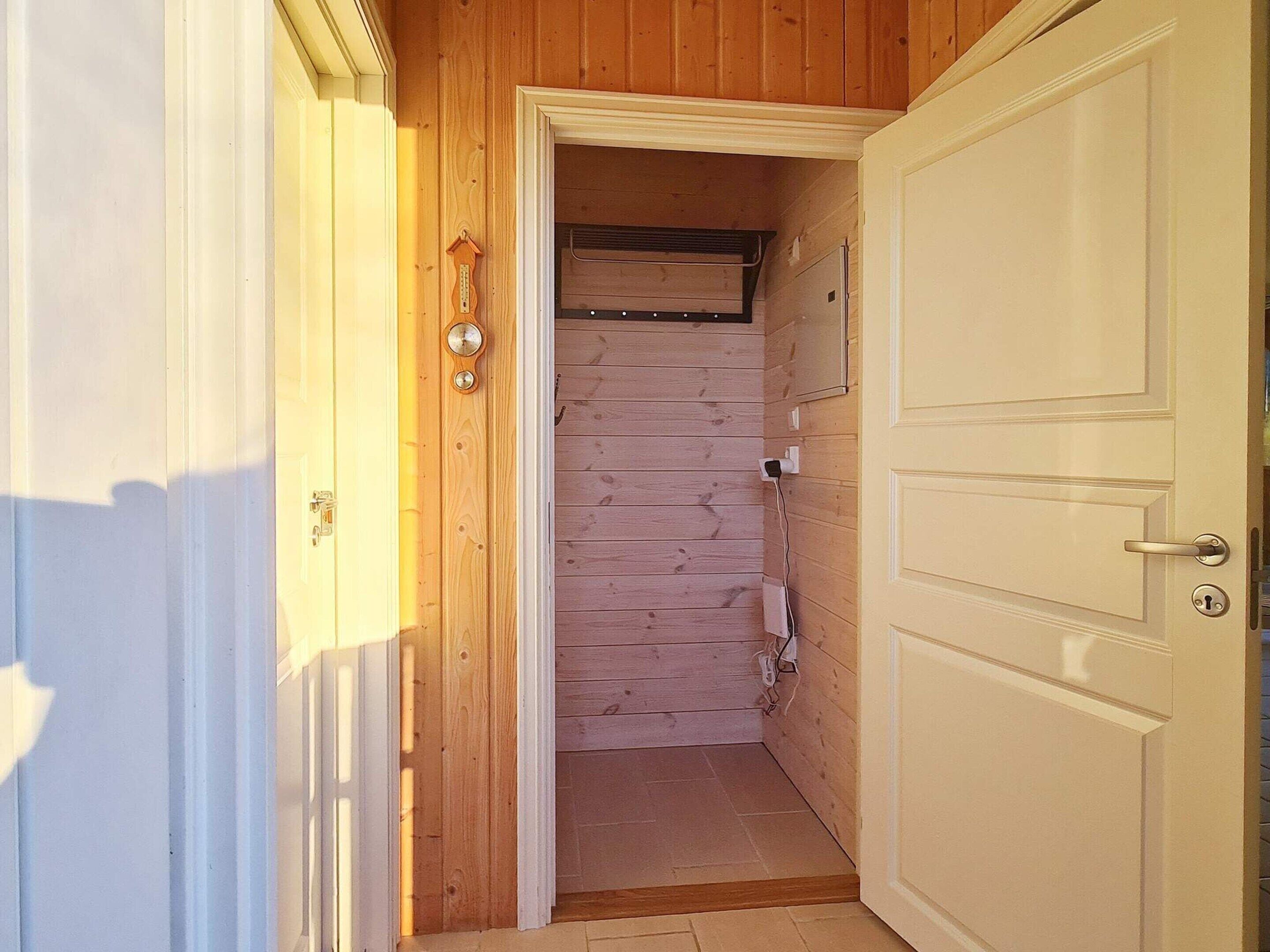 A narrow hallway with wooden walls and a white door on the right.