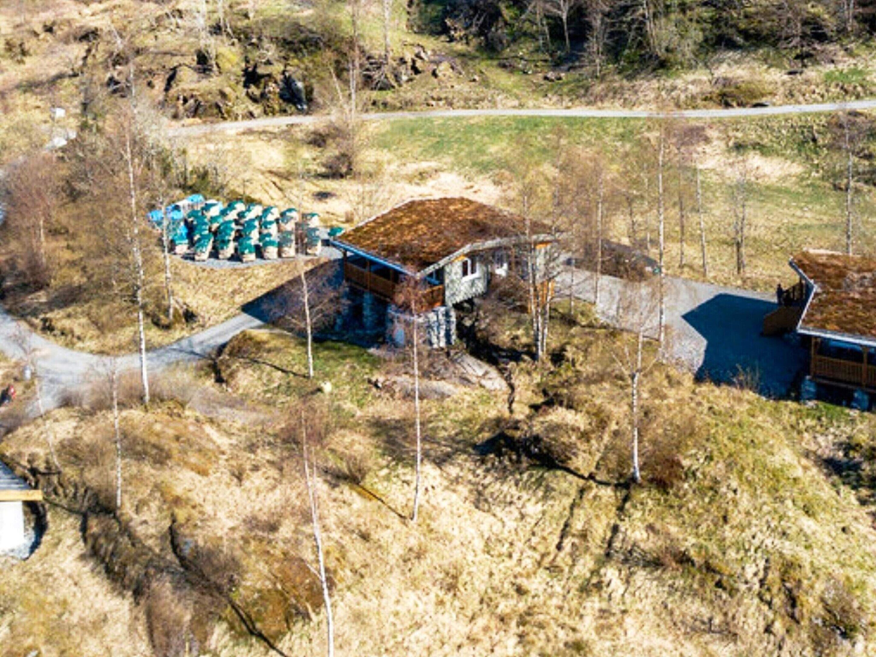 Eine rustikale Holzhütte mit Steinfundament, einer Holzdielen-Terrasse und einer kleinen Veranda.