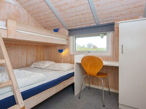 A bunk bed with a desk and chair, a window, and a wardrobe in a wooden room. - 8 Person Holiday Home in Sydals (Sydals)