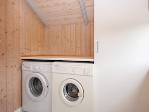 A laundry room with two front-loading washing machines and a wooden ceiling. - 8 Person Holiday Home in Sydals (Sydals)