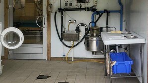 A compact kitchen with a sink, stove, and a washing machine. - 4 Star Holiday Home in Averoy (Averoy)
