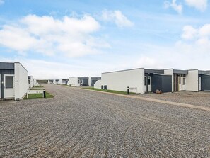 A row of modern, single-story buildings with a gravel driveway. - 4 Person Holiday Home in Vestervig (Vestervig)