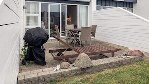 A patio with outdoor furniture, a grill, and a stone wall. - 4 Person Holiday Home in Vestervig (Vestervig)