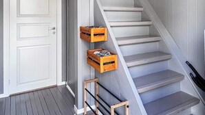Un escalier avec des marches blanches et une rampe en bois, menant à une porte blanche.