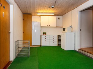 A compact kitchen with white cabinets, a microwave, and a refrigerator.