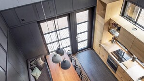 Een moderne keuken met een eethoek, grote ramen en uitzicht op de omgeving.