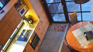 Une cuisine moderne avec des meubles en bois, un évier en acier inoxydable et un coin repas comprenant une table ronde et des chaises.