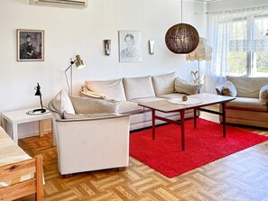 A modern living room with a sofa, coffee table, and a red rug. - 6 Person Holiday Home in Borgholm (Borgholm)