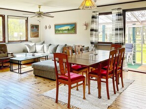 A spacious living room with a dining table, chairs, a sofa, and a ceiling fan. - 8 Person Holiday Home in Monsteras (Monsteras)