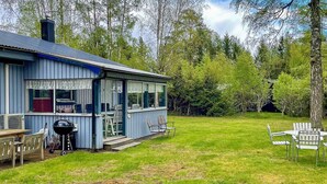 Une maison bleue avec un patio, un barbecue et des meubles pour s’asseoir à l’extérieur.