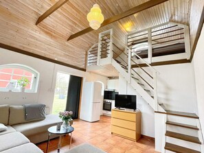 A modern interior with a staircase, a sofa, a dining table, and a kitchen area. - 3 Person Holiday Home in Berga (Berga)