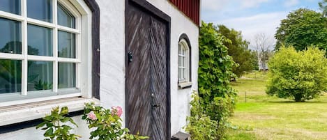 A house with a white exterior, a dark wooden door, and a window with a white frame.