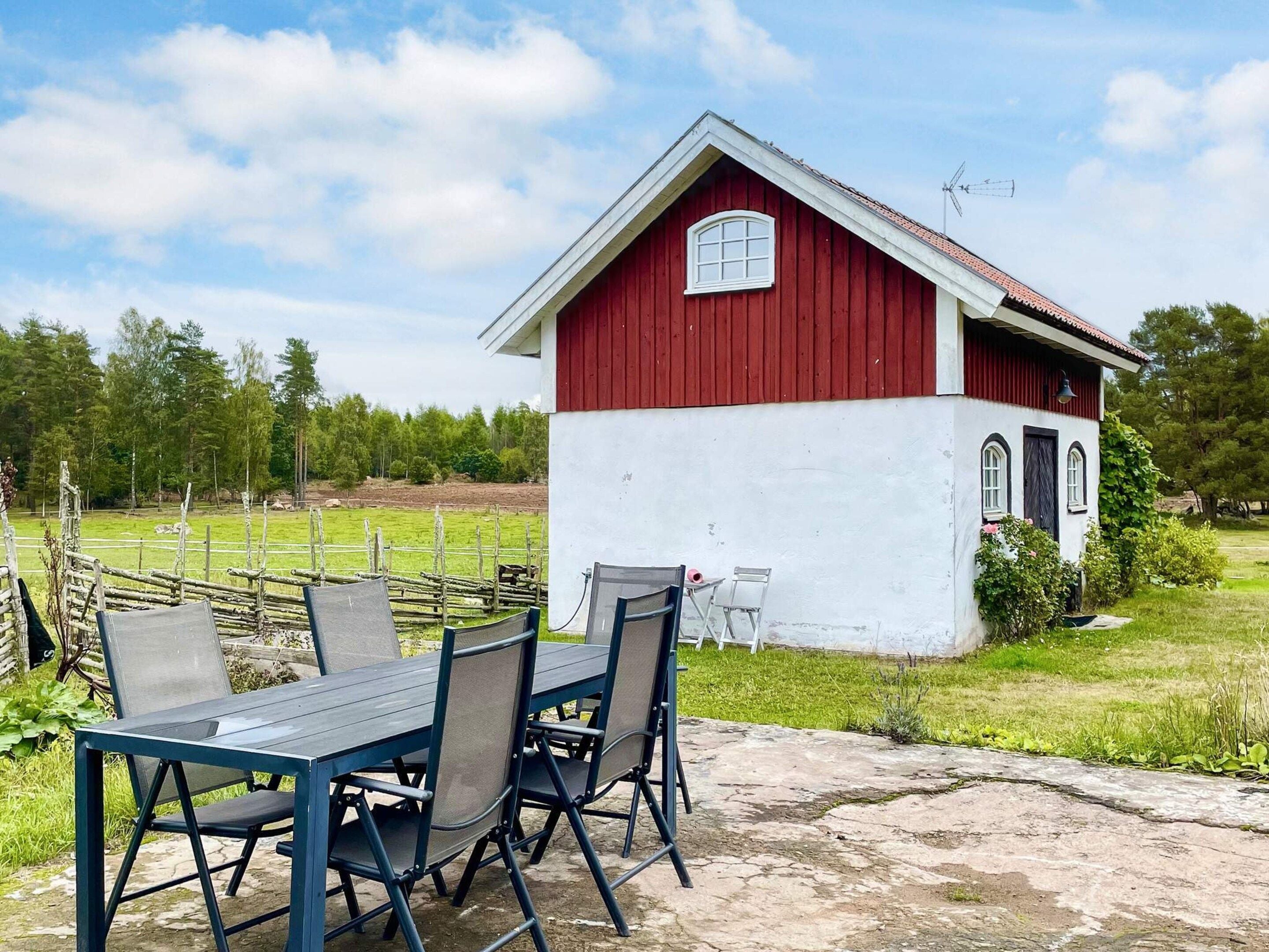 A red and white building with a small porch and a table with chairs in front.
