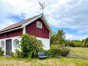 A red barn with a sloped roof, a chimney, and a satellite dish. - 3 Person Holiday Home in Berga (Berga)