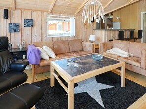A cozy living room with a wooden ceiling, a star-patterned rug, two sofas, a coffee table, and a television. - 8 Person Holiday Home in Hadsund (Hadsund)