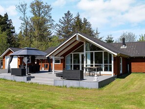 A modern house with a patio, a covered seating area, and a large window. - 8 Person Holiday Home in Hadsund (Hadsund)