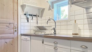 A kitchen with white cabinetry, a stainless steel sink, and a window above the countertop. - 4 Star Holiday Home in Granna (Gränna)