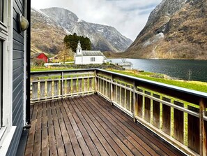 En træterrasse med udsigt over en sø og bjerge.