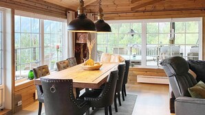 A dining area with a wooden table, black upholstered chairs, and pendant lighting. - 10 Person Holiday Home in Treungen-by Traum (Nissedal)