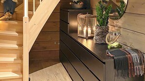 A staircase with wooden steps and a handrail, leading to a landing with a dark wooden console table. On the table, there are candles, a potted plant, and decorative items. - 10 Person Holiday Home in Treungen-by Traum (Nissedal)