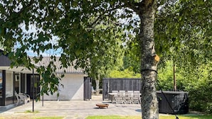A backyard with a hammock, a barbecue grill, and outdoor furniture. - 6 Person Holiday Home in Albaek (Aalbaek)