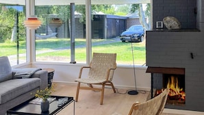 A modern living room with a fireplace, a sofa, a coffee table, and two chairs. - 6 Person Holiday Home in Albaek (Aalbaek)